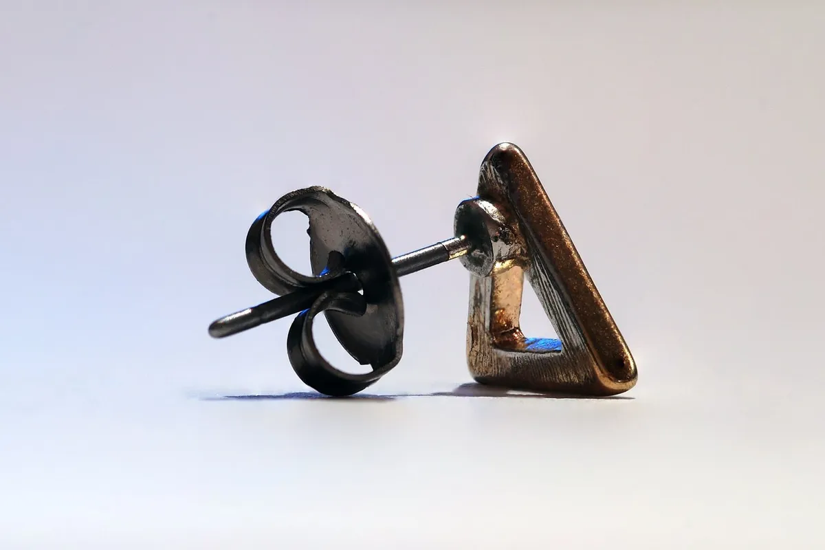 A stud earring with its butterfly back in close up