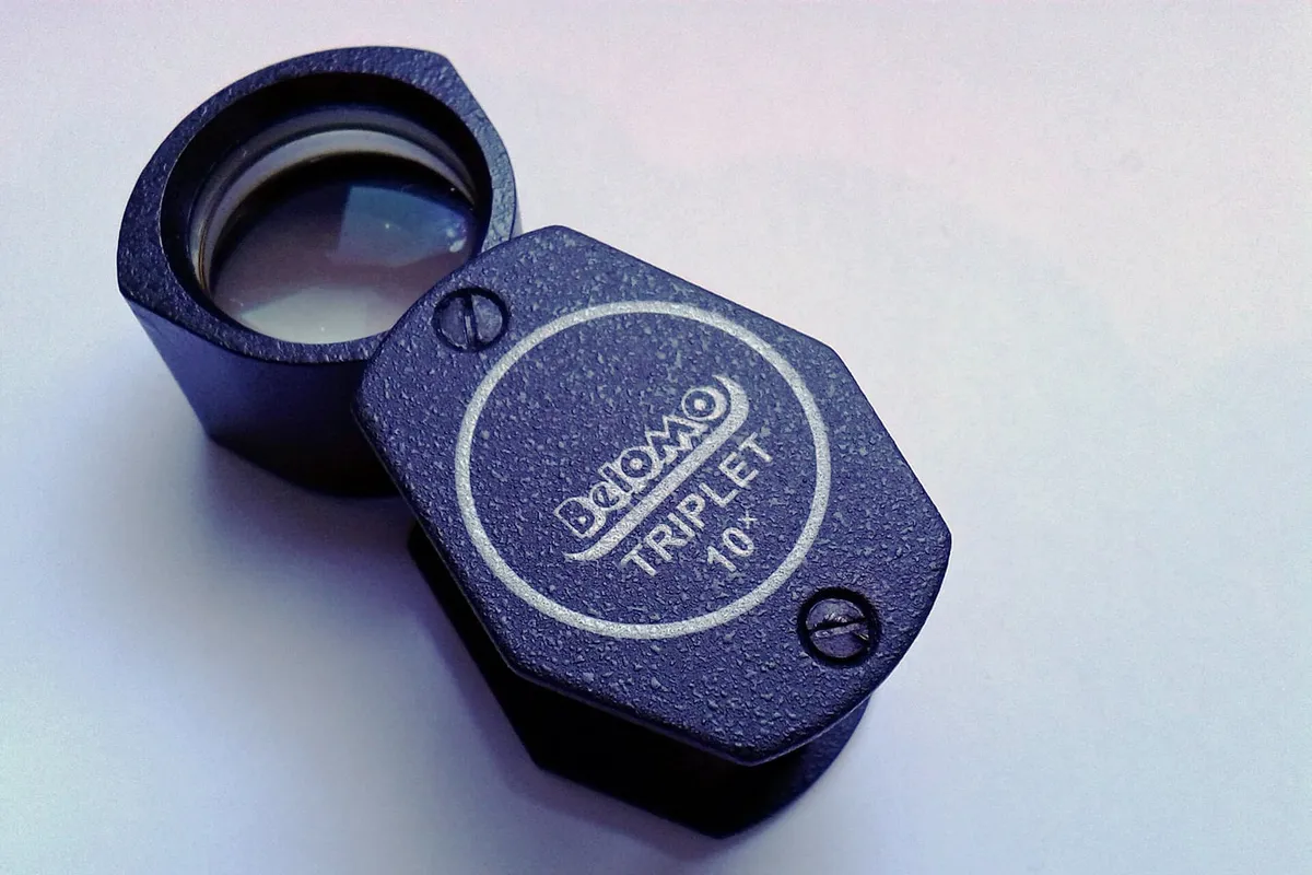 A ten-times jeweller's loupe on a plain surface